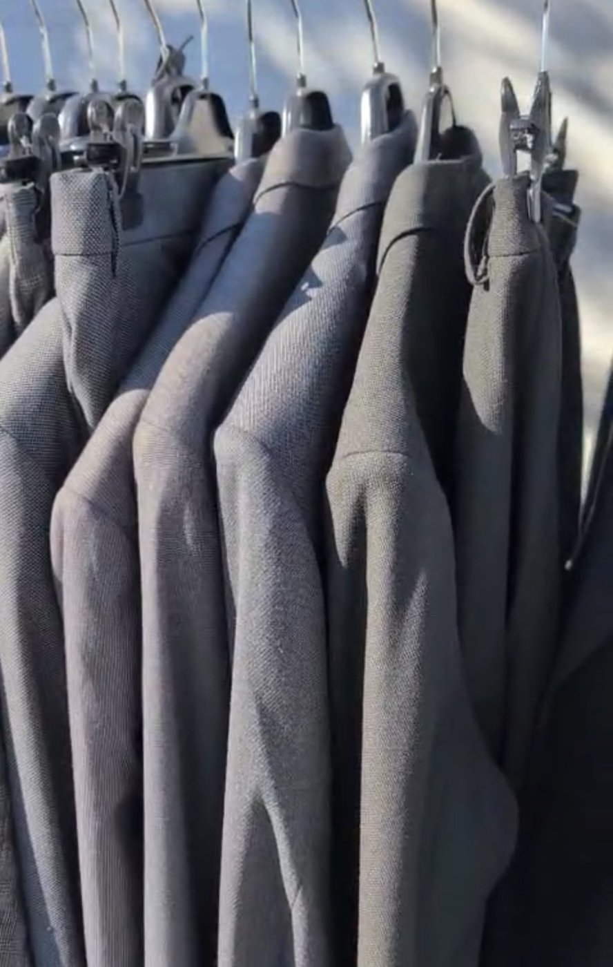 Rayon de pantalons de costume hommes gris alignés sur cintres