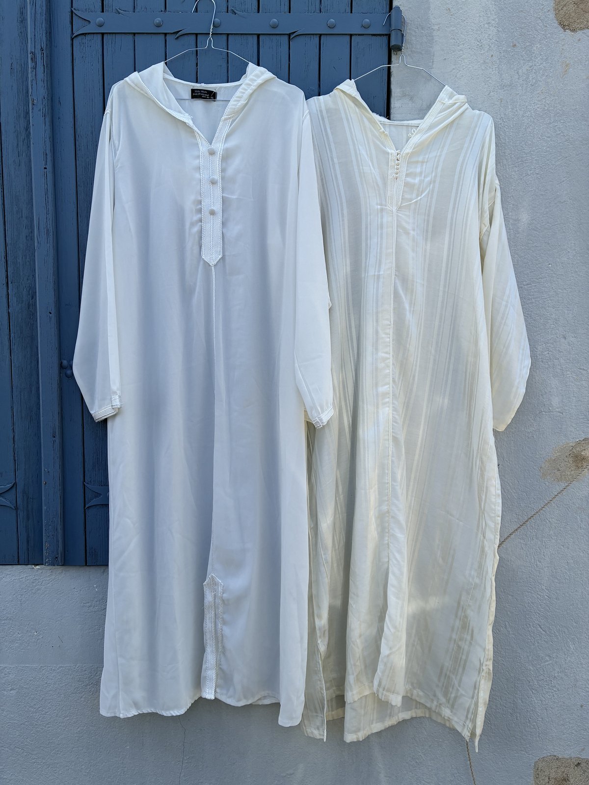 Deux jellabas blanches superposées, vue à plat — variations de tissus