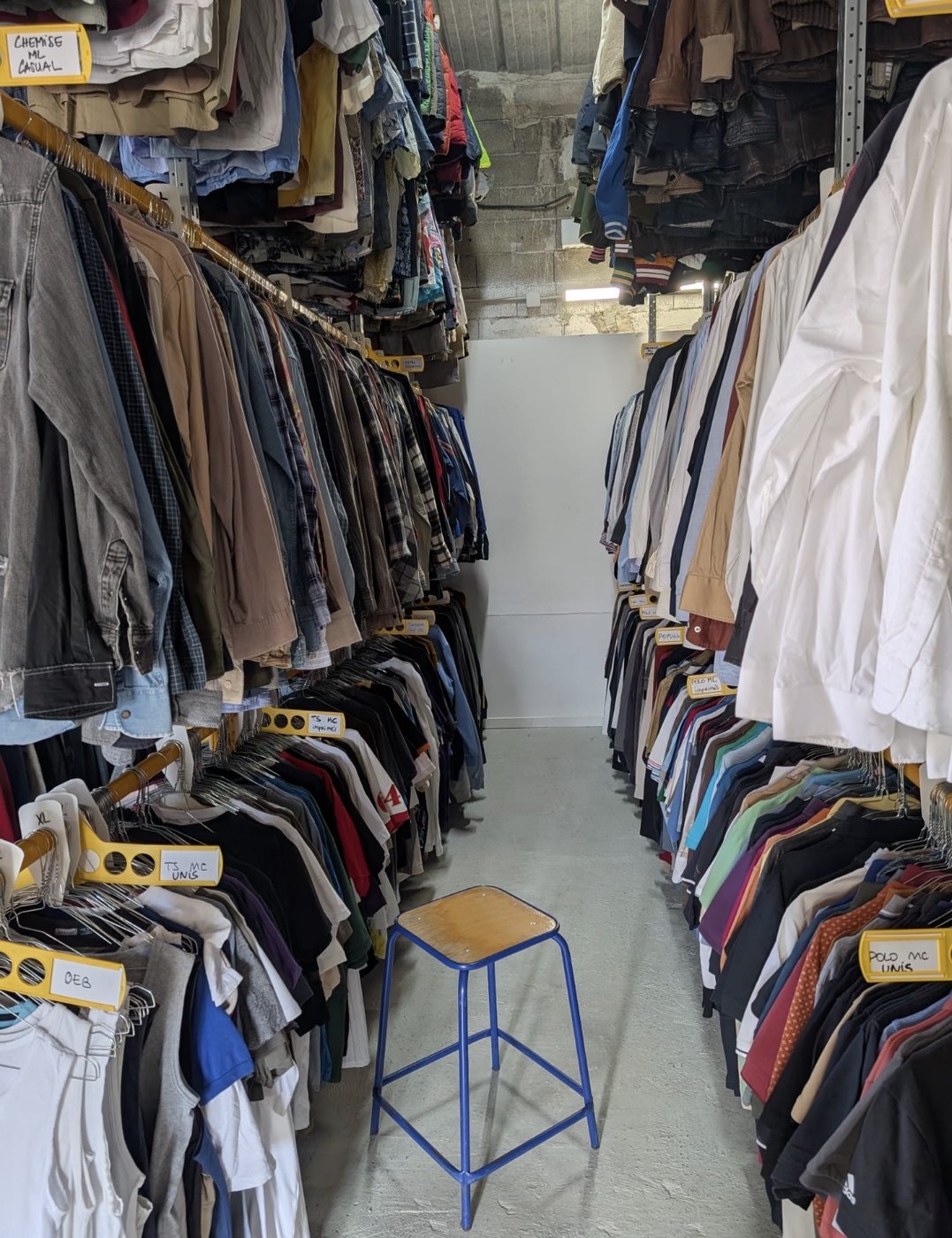 Allée de stock chemises et polos casual hommes, étiquettes organisées par silhouette