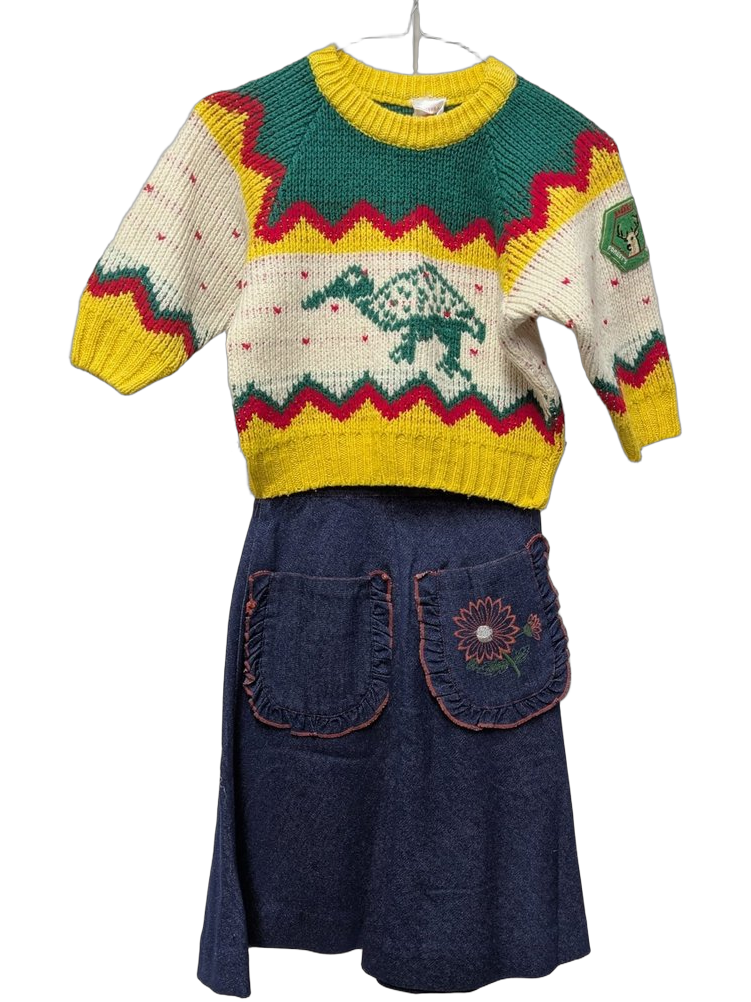 Tenue enfant années 80 : pull tricot à motifs zigzag jaune/vert sapin/rouge avec éléphant brodé au centre et écusson cerf, jupe en jean denim marine avec deux poches plaquées rondes brodées de tournesols