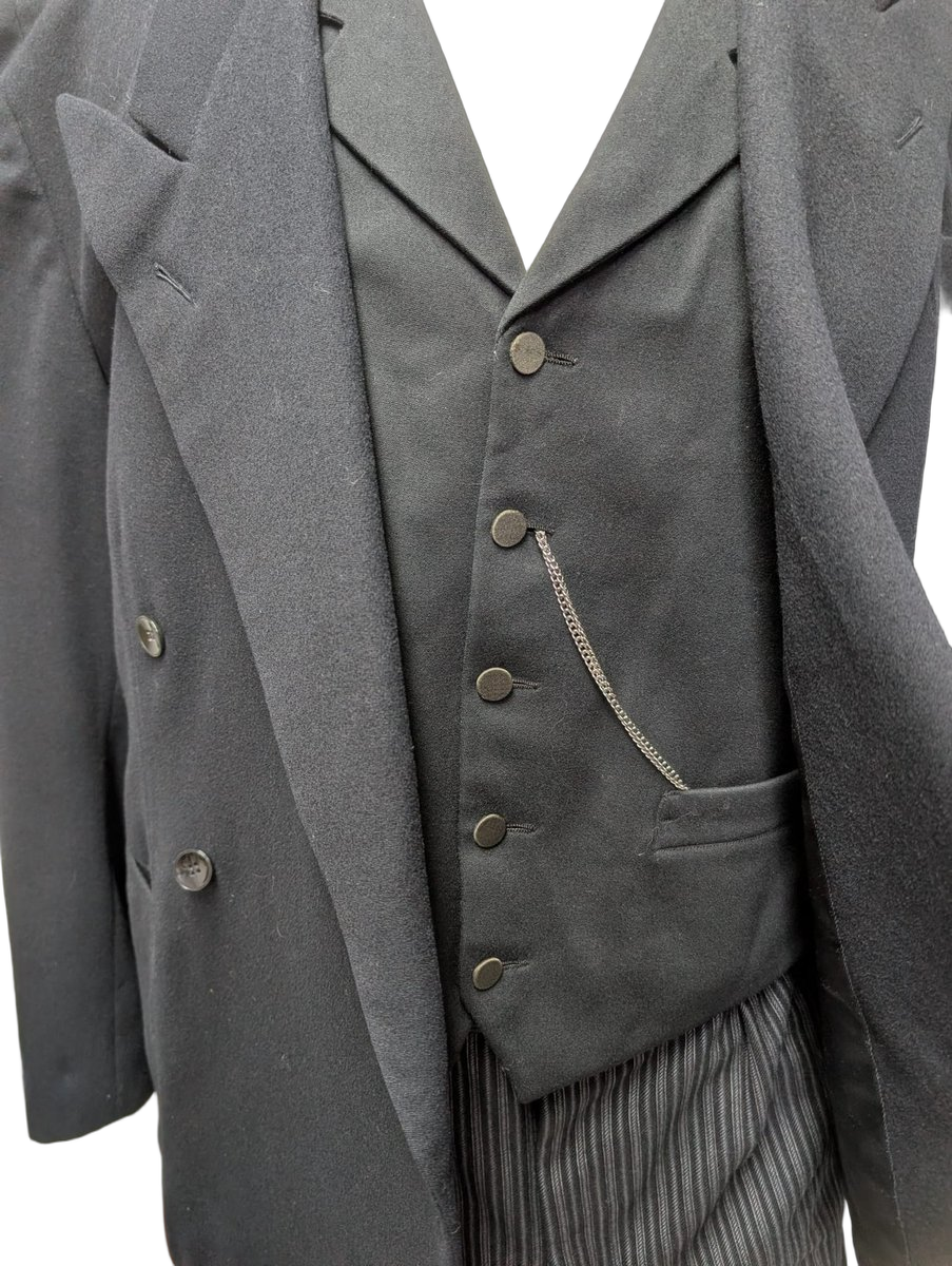 Gros plan détail du gilet noir 5 boutons avec chaîne de montre à gousset argentée, poche montre fendue. Détail typique d'une tenue masculine bourgeoise ou ouvrier endimanché, France 1900-1920