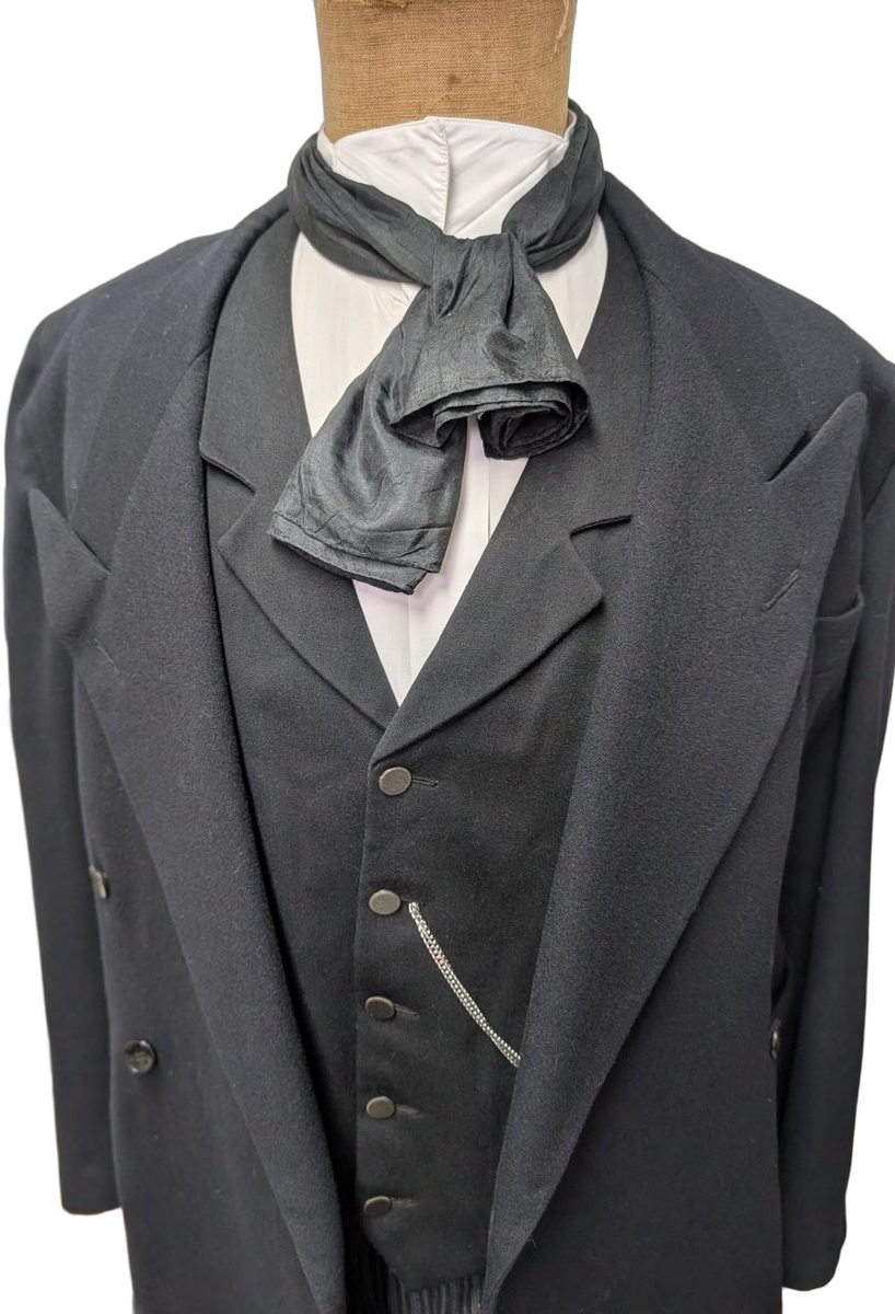 Détail Belle Époque : grande lavallière en soie noire nouée en plastron, col cassé blanc d'employé, revers du paletot, gilet avec chaîne de montre. Iconographie photographique fin XIXᵉ