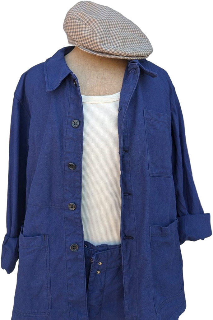 Détail buste : veste de Chauffe bleu marine 3 poches plaquées, débardeur côtelé blanc, casquette plate à carreaux beige