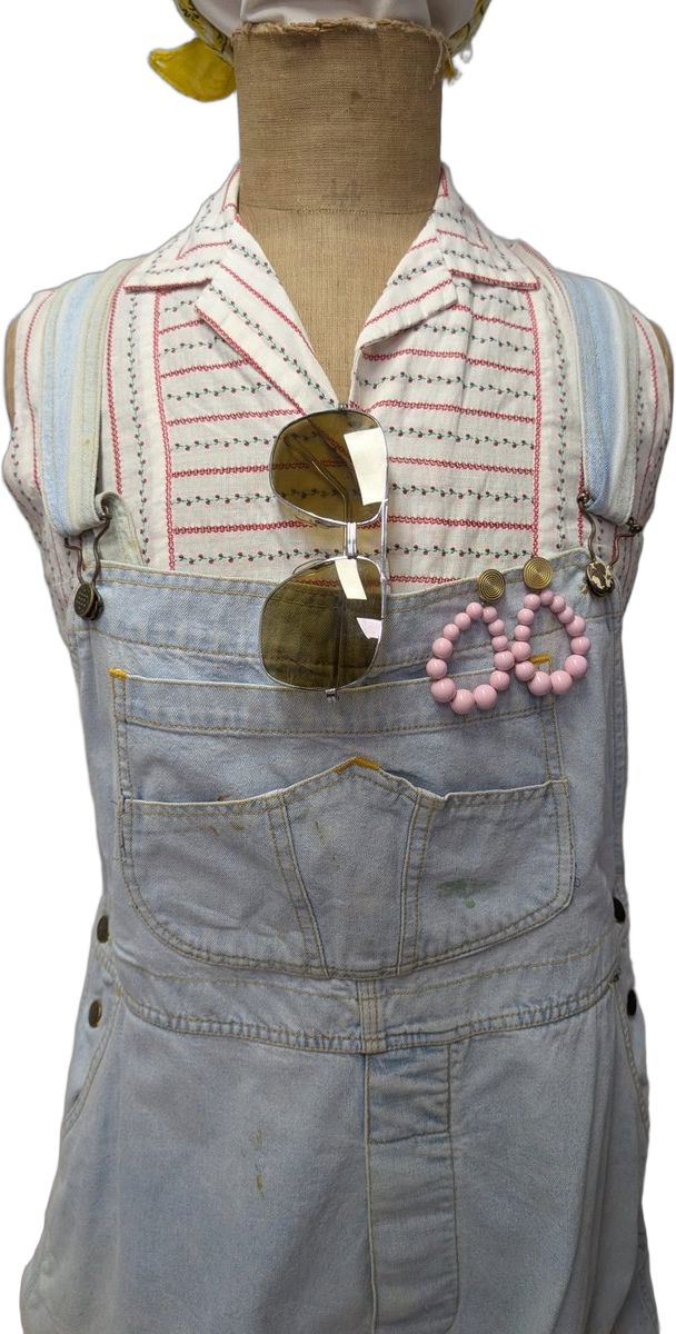 Détail buste : salopette jean avec chemisier rayé rouge/bleu pâle, lunettes aviator sur la poitrine, créoles en perles rose pastel